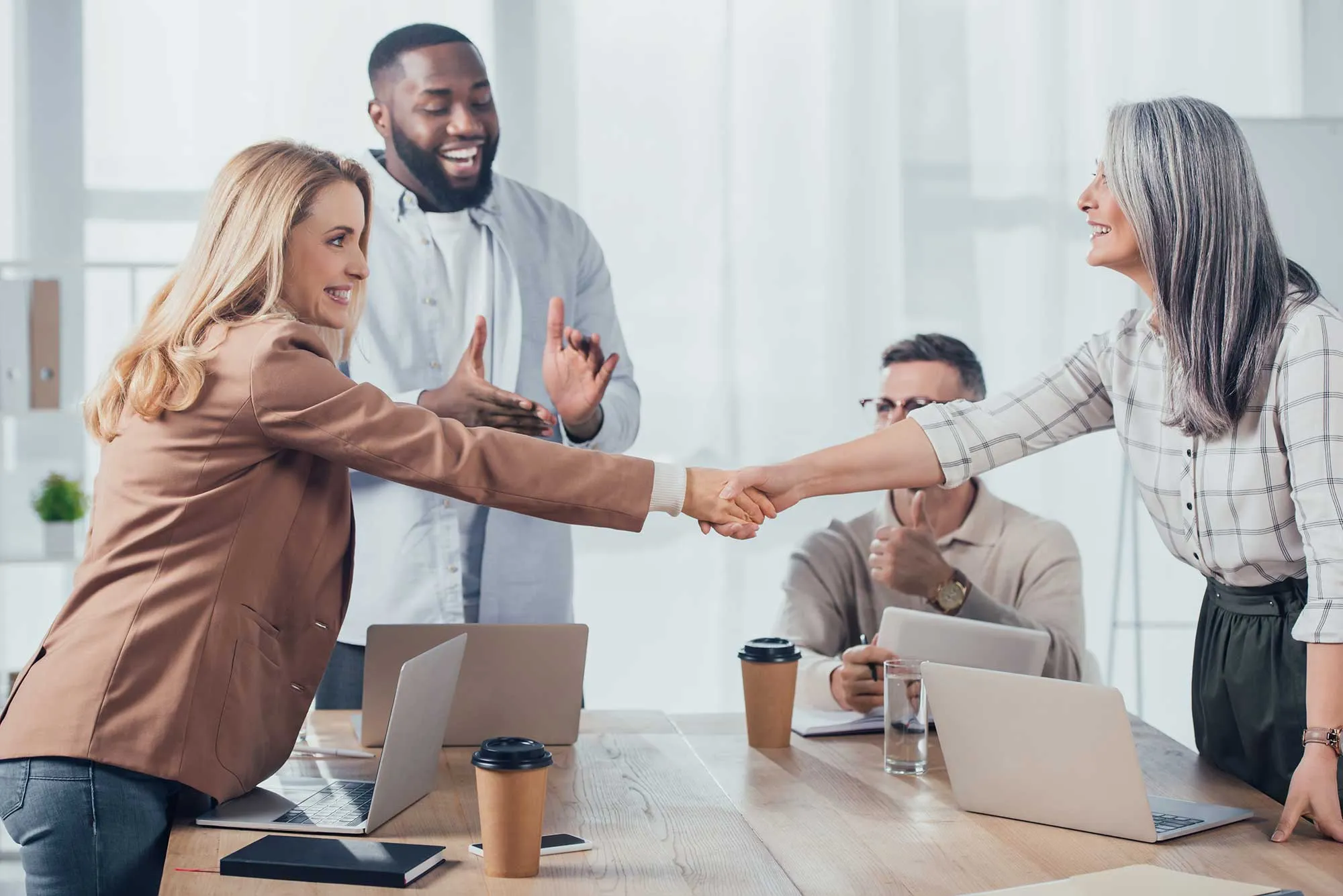 smiling-multicultural-colleagues-shaking-hands-dur-2022-12-16-19-22-49-utc